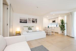 a white living room with a bed and a kitchen at Apartamento Golden Naimara in Cabanas de Tavira +23 photos