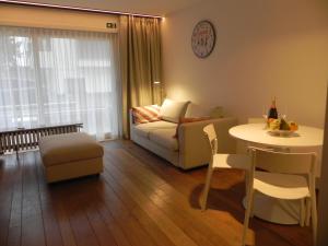a living room with a couch and a table at Silver Sunrise Studio in De Haan +17 photos
