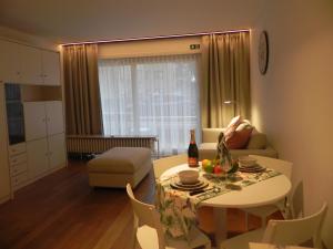 a living room with a table with a bottle of wine at Silver Sunrise Studio in De Haan