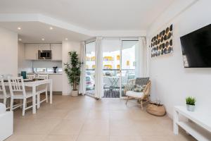 a kitchen and living room with a table and chairs at Apartamento Golden Naimara in Cabanas de Tavira