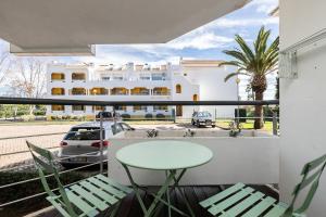 a balcony with a table and chairs and a building at Apartamento Golden Naimara in Cabanas de Tavira