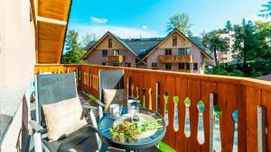 a patio with a table and chairs on a balcony at Apartamenty EverySky Nadrzeczna 3E-3D in Karpacz