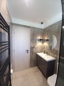 a bathroom with a sink and a toilet and a mirror at AAA Luxury Residences in Ioannina +98 photos