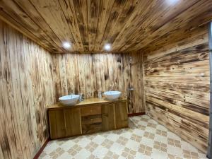 a bathroom with two sinks in a wooden wall at La Vie En Rose Ba Vì Homestay in Hanoi +48 photos