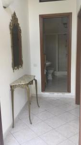 a bathroom with a table and a mirror and a toilet at Agriturismo Il Poderino in Tarquinia
