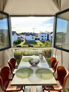 a table and chairs in a room with a large window at Privatwohnung Rüsselsheim nähe Hyundai Airport Messe etc in Königstädten