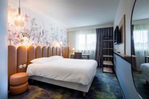 a hotel room with a large bed and a mirror at ibis Styles Pontivy centre Bretagne in Pontivy