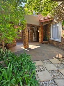 a brick house with a driveway leading to the front door at Krantz-Aloe guesthouse in Winterkamp