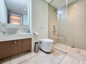 a bathroom with a toilet and a sink and a shower at Birds-eye canal view - Walk to CTICC and V&A Waterfront! in Cape Town