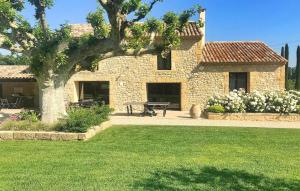 una casa de piedra con una mesa de picnic en un patio en Lovely Home In Le Thor With Wifi, en Le Thor