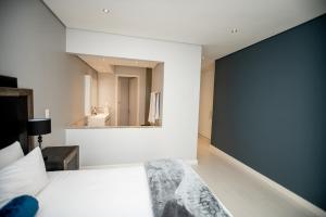 a bedroom with a bed and a large wall at One Hyde Park Apartments Sandton in Johannesburg