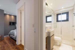 a bathroom with a sink and a toilet and a bed at Aconchego a 500m Rua Coberta by Achei Gramado in Gramado +20 photos