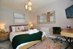 a bedroom with a bed with a mirror and a desk at Sandpiper Apartment in Benllech