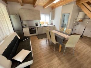 eine Küche und ein Esszimmer mit Tisch und Stühlen in der Unterkunft Căsuță la țară - liniște și viață rurală cotidiană in Cîrţa