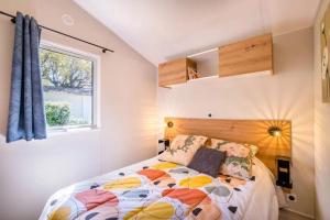 une chambre avec un lit et une fenêtre dans l'établissement Bungalow charmant à Saint-Raphaël, à Saint-Raphaël