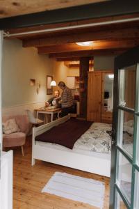 two people in a bedroom with a large bed at Ferienhof Spiegelhaus in Krummhörn