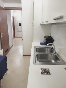 een keuken met een spoelbak en een aanrechtblad bij Appartamenti Le Gemme in Napels