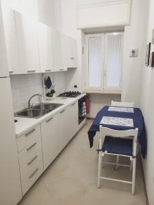 een keuken met witte kasten, een wastafel en een tafel bij Appartamenti Le Gemme in Napels +211 foto's