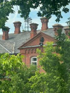 a brick building with two chimneys on top of it at Jaukus apartamentas Birzu centre in Biržai