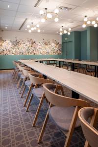 an empty room with rows of tables and chairs at ibis Styles Pontivy centre Bretagne in Pontivy