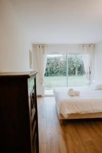 a bedroom with a bed and a large window at Maison Vue Mer - Plage à Pied in La Trinité-sur-Mer