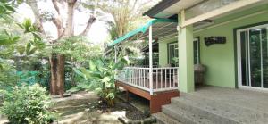 a porch of a green house with a bench at Bassara House 2 bedroom in Koh Lone