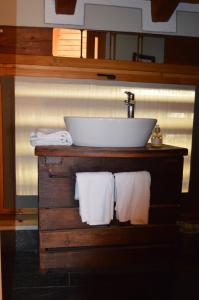 een badkamer met een wastafel en witte handdoeken bij Maison de Noé in Arnad