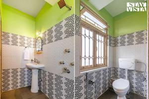 a bathroom with a toilet and a sink and a window at StayVista at Luitel Homestay with Mountain View in Gangtok +15 photos