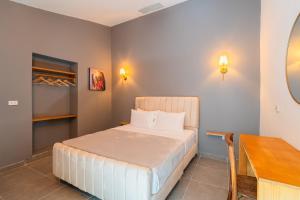 Un pequeño dormitorio con una cama y una mesa. en Casa Del Pozo Boutique House, en Cartagena de Indias