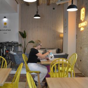 a woman sitting at a table in a restaurant at Original Domino House in Valencia