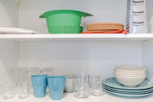 a shelf with bowls and glasses on it at Maison Fontanieres studio Le Roule in La Mulatière