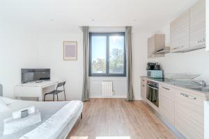 Habitación blanca con cama y cocina con escritorio. en Maison Fontanières Studio Laurent 2 persons, en La Mulatière