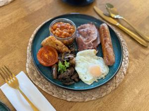 a blue plate of breakfast food with eggs sausage and beans at The Olivers Guest House in Hereford