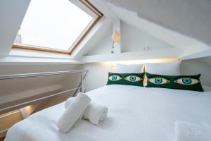 a bedroom with a white bed with blue eyes pillows at SHWAY - The Seaman's Sight in Antwerp