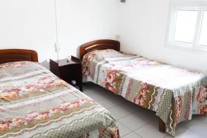 two beds sitting next to each other in a room at Villas Floralies in Grand-Baie