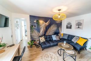 a living room with a blue couch and a table at Double Appartement Parking Honfleur 10min plage in Honfleur