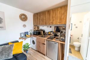 a kitchen with wooden cabinets and a washer and dryer at Double Appartement Parking Honfleur 10min plage in Honfleur