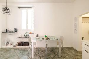 a white kitchen with a dining room table and chairs at B22- Casa Bassi, vicino Autodromo Imola -Villa Maria Hospital in Massa Lombarda