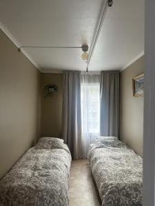 two beds in a bedroom with a window at Huset Vårt in Hornindal
