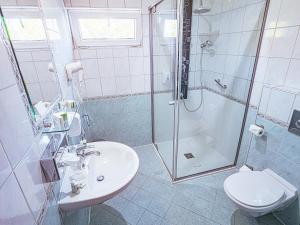 a bathroom with a sink and a shower and a toilet at Holiday Beach Budapest Wellness Hotel with Sauna Park in Budapest