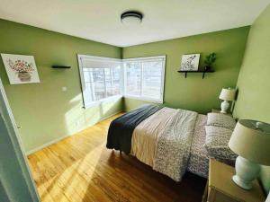 - une chambre avec des murs verts, un lit et une fenêtre dans l'établissement Bo's charming two bedroom with shared HOT TUB, à Billings