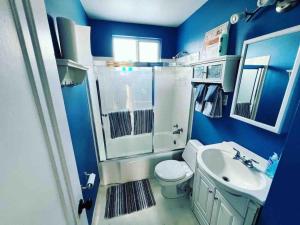 une salle de bain bleue avec des toilettes et un lavabo dans l'établissement Bo's charming two bedroom with shared HOT TUB, à Billings 9 autres photos