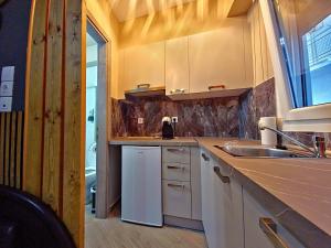 a kitchen with white cabinets and a sink at Gpxclr MicroLuxeSuite in Larisa