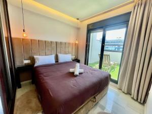丹吉尔Natural Harmony Suite - 2 BR Marina Bay Beach View的一只泰迪熊坐在卧室的床上 更多21张照片
