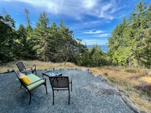 Nanoose BayにあるOceanview Guest Suite with Large 2 Person Soaker Tubの椅子2脚、テーブル1脚、砂利椅子1脚