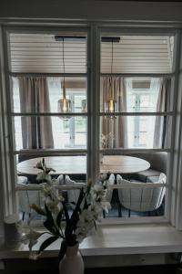a dining room with a table and a vase with flowers at Huset Vårt in Hornindal