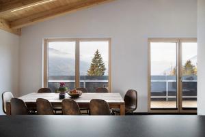 a dining room with a table and chairs and windows at Apart Mountainview in Rohrberg