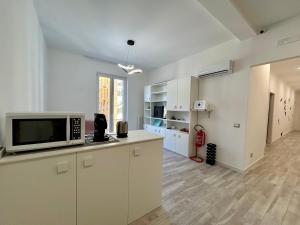 a kitchen with white cabinets and a microwave at Prospettiva Medina in Naples