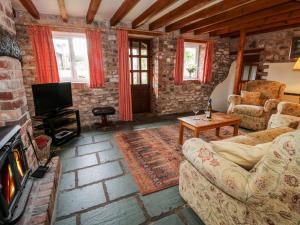 a living room with a couch and a fireplace at Heron Cottage in Shrewsbury