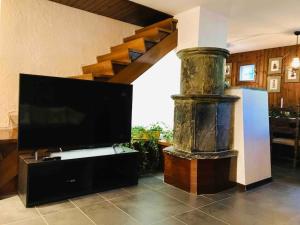 a living room with a television and a large fireplace at Large Taverna 2BR 2BA Steps to Lift Full Kitchen in Courmayeur